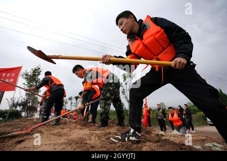 (211010) -- HEJIN, 10 ottobre 2021 (Xinhua) -- i soccorritori fortificano la diga temporanea contro l'alluvione nel villaggio di Lianbo a Hejin City, provincia di Shanxi della Cina settentrionale, 10 ottobre 2021. Più di 120,000 persone sono state evacuate temporaneamente dopo continue deflussi innescati alluvioni nella provincia di Shanxi nella Cina settentrionale, ha detto le autorità Domenica. Le inondazioni hanno sconvolto la vita di 1.76 milioni di residenti provenienti da 76 contee, città e distretti, secondo il dipartimento provinciale di gestione delle emergenze. Circa 190,000 ettari di colture sono stati danneggiati e più di 17,000 case crollate, la departme Foto Stock