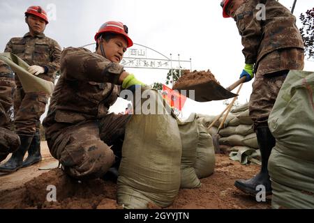 (211010) -- HEJIN, 10 ottobre 2021 (Xinhua) -- i soccorritori fortificano la diga temporanea contro l'alluvione nel villaggio di Lianbo a Hejin City, provincia di Shanxi della Cina settentrionale, 10 ottobre 2021. Più di 120,000 persone sono state evacuate temporaneamente dopo continue deflussi innescati alluvioni nella provincia di Shanxi nella Cina settentrionale, ha detto le autorità Domenica. Le inondazioni hanno sconvolto la vita di 1.76 milioni di residenti provenienti da 76 contee, città e distretti, secondo il dipartimento provinciale di gestione delle emergenze. Circa 190,000 ettari di colture sono stati danneggiati e più di 17,000 case crollate, la departme Foto Stock