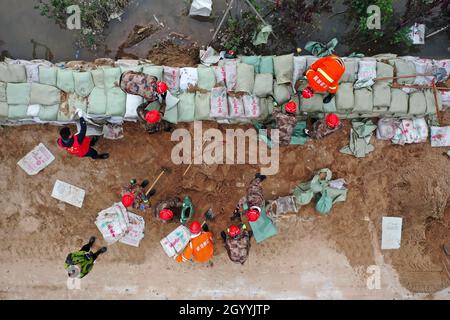 (211010) -- HEJIN, 10 ottobre 2021 (Xinhua) -- Fotografia aerea mostra i soccorritori che fortificano la diga temporanea contro l'alluvione al villaggio di Lianbo a Hejin City, provincia di Shanxi della Cina settentrionale, 10 ottobre 2021. Più di 120,000 persone sono state evacuate temporaneamente dopo continue deflussi innescati alluvioni nella provincia di Shanxi nella Cina settentrionale, ha detto le autorità Domenica. Le inondazioni hanno sconvolto la vita di 1.76 milioni di residenti provenienti da 76 contee, città e distretti, secondo il dipartimento provinciale di gestione delle emergenze. Circa 190,000 ettari di colture sono stati danneggiati e più di 17,000 case c Foto Stock