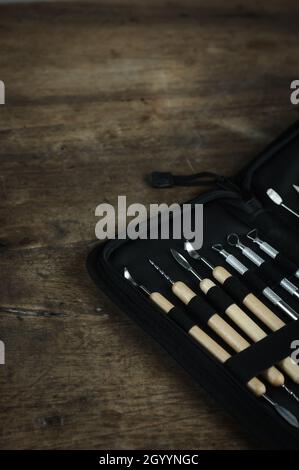 Kit di utensili per scultura su sfondo di un tavolo in legno. Primo piano dettaglio set di argilla ceramica o plastilina Foto Stock