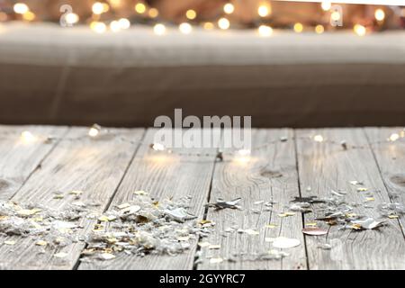 Sfondo natalizio in legno con luci sfocate e dettagli decorativi. Foto Stock