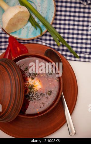 Borsch rosso ucraino con panna acida, aglio e cipolline verdi. Primo piatto. Cena. Un piatto tradizionale. Cibo ucraino sul tavolo. Foto Stock
