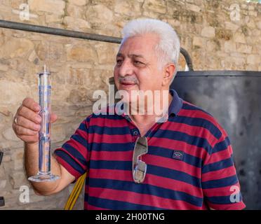 La produzione della Zivania è stata dimostrata dal proprietario della distilleria Avraamides di Arsos, Cipro. La Zivania è una bevanda alcolica tradizionale di Cipro. Foto Stock