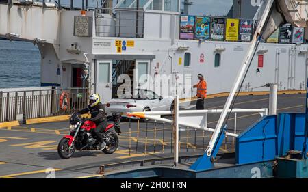 Torpoint, Cornovaglia, Inghilterra, Regno Unito. 2021. Carico di automobili e scarico di motociclisti da un rotolo su rool fuori della catena di traghetti che attraversa il fiume Tamar betwe Foto Stock