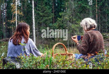picknic nella foresta, le donne al picnic e raduno dei funghi Foto Stock