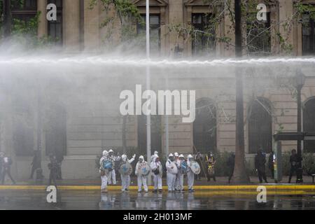 Santiago, Metropolitana, Cile. 10 Ott 2021. La polizia spara gas lacrimogeni e usa cannoni ad acqua per disperdere i manifestanti a Santiago, Cile, durante una dimostrazione per commemorare il giorno della gara, o Columbus Days. Ottobre 10, 2021. (Credit Image: © Matias Basualdo/ZUMA Press Wire) Foto Stock