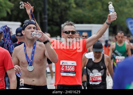 Chicago, Illinois, Stati Uniti. 10 Ott 2021. Una maratona festeggia al traguardo della 43° Bank of America Chicago Marathon, domenica 10 ottobre 2021. Si stima che circa 35,000 persone partecipino ai 26.2 chilometri di percorso pianeggiante che attraversa diversi quartieri dal centro città a molte comunità circostanti a Chicago. (Credit Image: © Pat A. Robinson/ZUMA Press Wire) Foto Stock