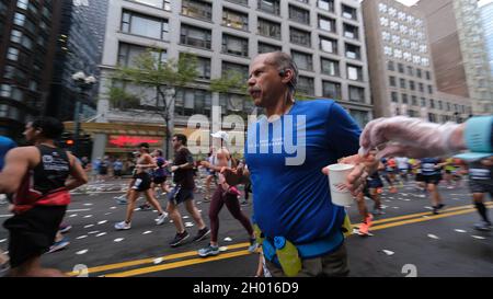 Chicago, Illinois, Stati Uniti. 10 Ott 2021. Un runner afferra una tazza di acqua da una stazione di acqua verso sud su state Street durante la 43rd Bank of America Chicago Marathon, domenica 10 ottobre 2021. Si stima che circa 35,000 persone partecipino ai 26.2 chilometri di percorso pianeggiante che attraversa diversi quartieri dal centro città a molte comunità circostanti a Chicago. (Credit Image: © Pat A. Robinson/ZUMA Press Wire) Foto Stock