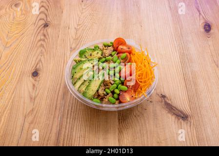 ciotola vegana con pollo di verdure heura a base di soia con fagioli di edamame, pomodori ciliegini, pezzi di avocado maturo e carota grattugiata Foto Stock