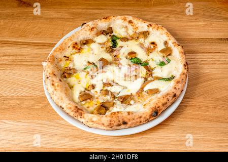 Pizza italiana con tartufata con frullato di funghi confit, olio di girasole, capperi, acciughe, olive nere, tartufo nero e aglio Foto Stock