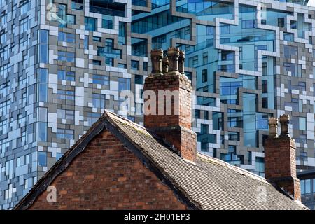 Un cottage in mattoni in vecchio stile di fronte al moderno edificio Cube nel centro di Birmingham, Regno Unito. Foto Stock