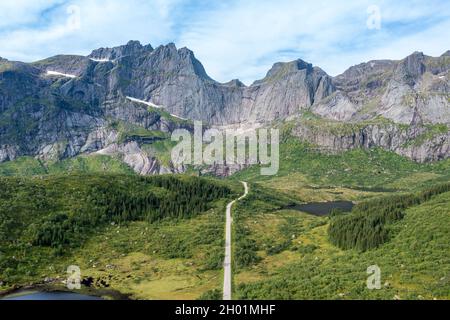 Veduta aerea della strada in montagna scenario, passando laghi e prati, strada da E10 al villaggio Nusfjord, Lofoten, Norvegia Foto Stock