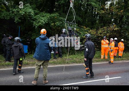 Wendover, Regno Unito. 10 ottobre 2021. Gli agenti di controllo della National Eviction Team (NET) iniziano i lavori per sgombrare gli attivisti ambientali che si oppongono al collegamento ferroviario ad alta velocità HS2 dal campo di resistenza attiva (GUERRA) di Wendover. IL campo DI GUERRA, che contiene case di alberi, gallerie, una gabbia e una torre di 15 metri, è attualmente il più grande dei campi di protesta allestiti dagli attivisti della Stop HS2 lungo la fase 1 dell'HS2 tra Londra e Birmingham. Credit: Mark Kerrison/Alamy Live News Foto Stock