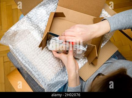 Vista dall'alto del disimballaggio manuale dell'unità disco rigido Western Digital HDD da donna in confezione di plastica con protezione a bolle d'aria Foto Stock