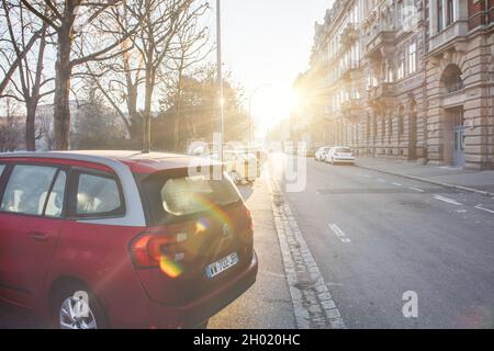 La luce del sole si affaccia su una strada francese con un bel grande edificio haussmanniano Foto Stock