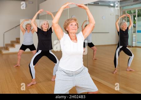 La donna anziana che pratica la danza balletto si muove nello studio coreografico Foto Stock