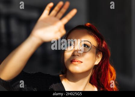 Ritratto di una donna asiatica sorridente che indossa occhiali, bella donna coreana che posa guardando la macchina fotografica in posa per la foto Foto Stock