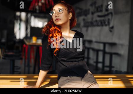 Ritratto di una donna asiatica sorridente che indossa occhiali, bella donna coreana che posa guardando la macchina fotografica in posa per la foto Foto Stock