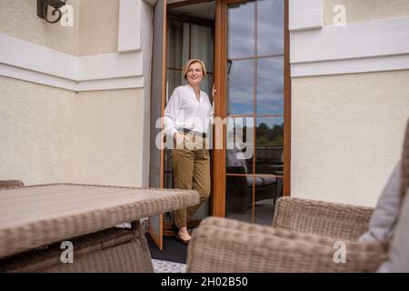 Gioiosa bella signora caucasica alla porta d'ingresso Foto Stock