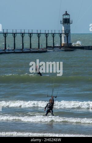 St Joseph MI USA, 26 settembre 2021; due kite surfisti tengono le linee strette per gli aquiloni mentre si godono le onde attive sul lago Michigan Foto Stock