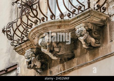 Bel mascaron barocco ornamento di un balcone nel centro storico di Ragusa, Sicilia Foto Stock