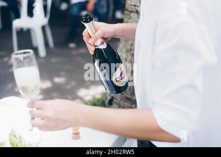 NORALA, PH– 22 SETTEMBRE 2021: Mani che tengono la bottiglia di vino frizzante Martini e un vino alto. Messa a fuoco selettiva. Spazio di copia. Foto Stock