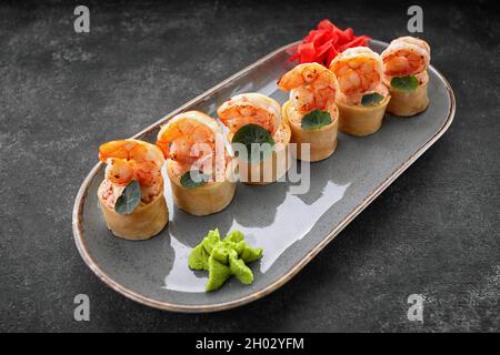 Sushi rotolini con omelette, gamberetti e bastoncini di granchio Foto Stock