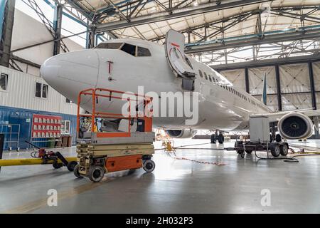 Velivolo passeggeri in manutenzione del motore e riparazione fusoliera in hangar Foto Stock