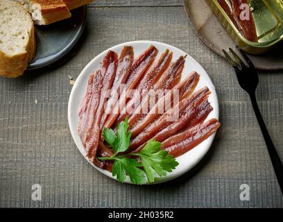 piatto di acciughe in scatola su tavolo da cucina in legno, vista dall'alto Foto Stock