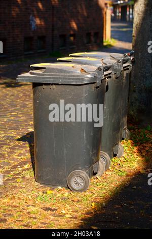 Riciclaggio di bidoni per rifiuti, bidoni per rifiuti residui in piedi sul marciapiede, Germania, Europa Foto Stock