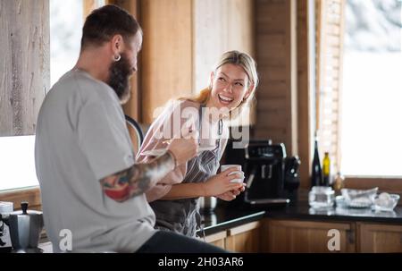 Coppia matura divertirsi in cucina e mangiare al coperto in cucina, vacanze invernali in appartamento privato. Foto Stock