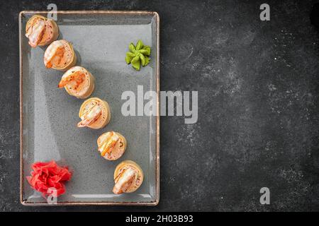 Sushi rotolini con omelette, gamberetti e bastoncini di granchio Foto Stock