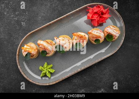 Sushi rotolini con omelette, gamberetti e bastoncini di granchio Foto Stock