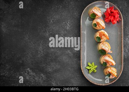 Sushi rotolini con omelette, gamberetti e bastoncini di granchio Foto Stock