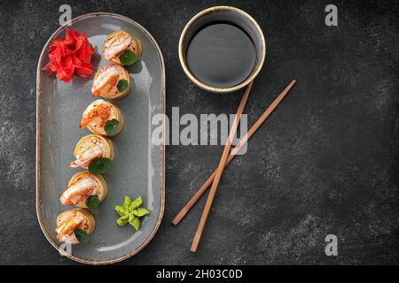 Sushi rotolini con omelette, gamberetti e bastoncini di granchio Foto Stock