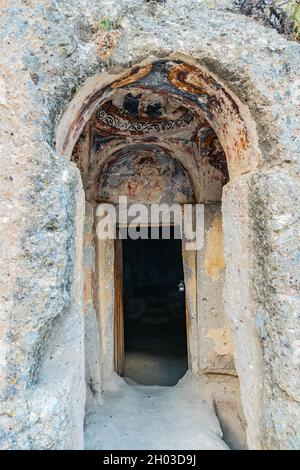 La Valle di Soganli offre una vista mozzafiato e pittoresca dell'ingresso del chiostro in un giorno del cielo blu in estate Foto Stock