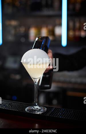 il barman sta facendo un cocktail con una bolla d'aria fumosa Foto Stock