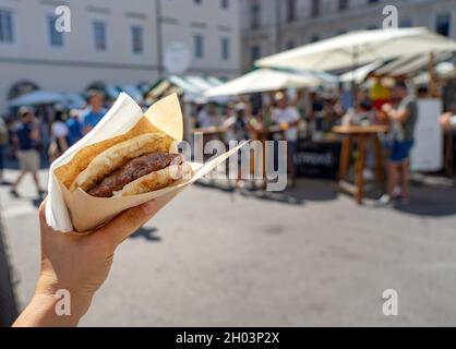 Pljeskavica in lepinja a Ljubljana sulla cucina a vista odprta kuhna evento gastronomico . Foto Stock