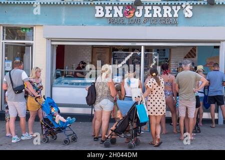 I vacanzieri fanno la fila per il gelato presso un negozio ben & Jerrys nel centro di Newquay, in Cornovaglia. Foto Stock