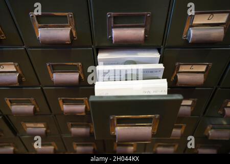 Aprire il cassetto dei file di archivio su un vecchio armadio di archiviazione in metallo Foto Stock