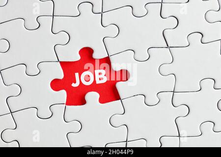 La parola job scritto sul pezzo di puzzle rosso mancante. Per cercare di per trovare un concetto di lavoro. Foto Stock