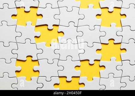 Pezzi di puzzle mancanti con sfondo giallo. Foto Stock