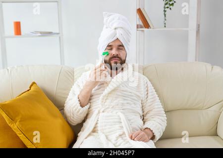 Uomo bearded con strumento di massaggio facciale. Cura della pelle maschile e concetto spa. Foto Stock