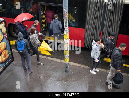 Belgrado, Serbia, 7 ottobre 2021: Passeggeri che entrano in un autobus cittadino sotto la pioggia Foto Stock