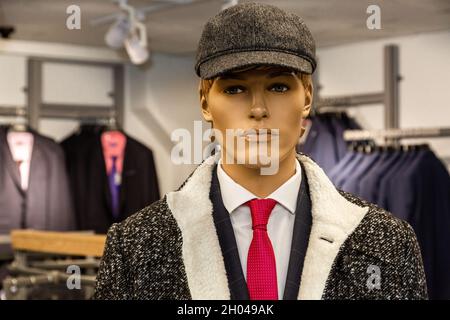 Manichino maschile vestito in autunno, abito classico con cravatta rossa e berretto grigio. Guarda dritto la fotocamera. Foto Stock