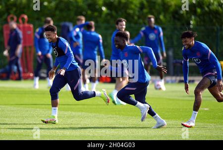 Jadon Sancho, Bukayo Saka e Tyrone Mings (sinistra-destra) in Inghilterra durante una sessione di allenamento presso Hotspur Way Training Ground, Londra. Data foto: Lunedì 11 ottobre 2021. Foto Stock