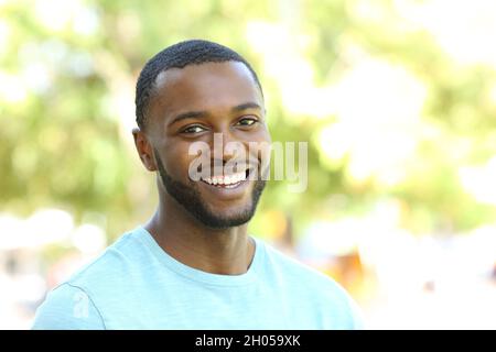 Ritratto di un felice uomo nero sorridente alla macchina fotografica in un parco Foto Stock