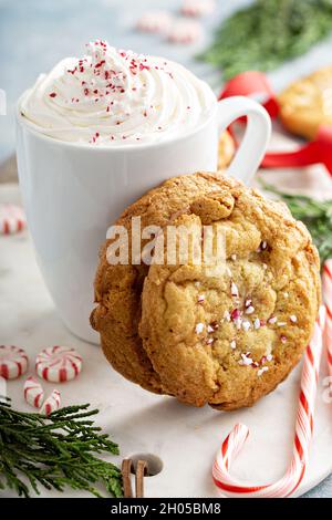 Biscotti al cioccolato bianco alla menta peperita appena sfornati per Natale serviti con cioccolata calda Foto Stock