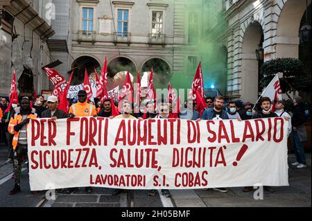 Torino, Italia. 11 ottobre 2021. I manifestanti hanno una bandiera durante uno sciopero generale chiamato dai sindacati popolari (Cobas, Cub, USB) contro il governo Draghi. Alla protesta hanno partecipato circa 2000 persone tra cui gli studenti e le cosiddette persone "No Green Pass". Credit: Nicolò campo/Alamy Live News Foto Stock