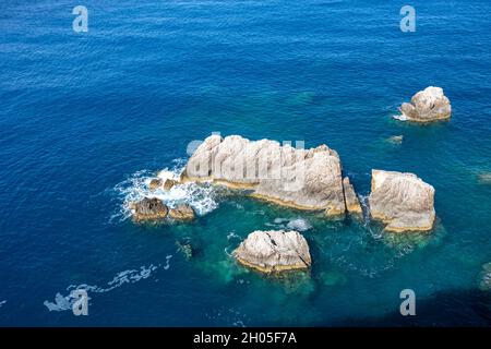 Onde calme intorno alle rocce nel mare azzurro e limpido dello Ionio. Natura estiva nell'isola di Lefkada, Grecia. Vista dall'alto Foto Stock